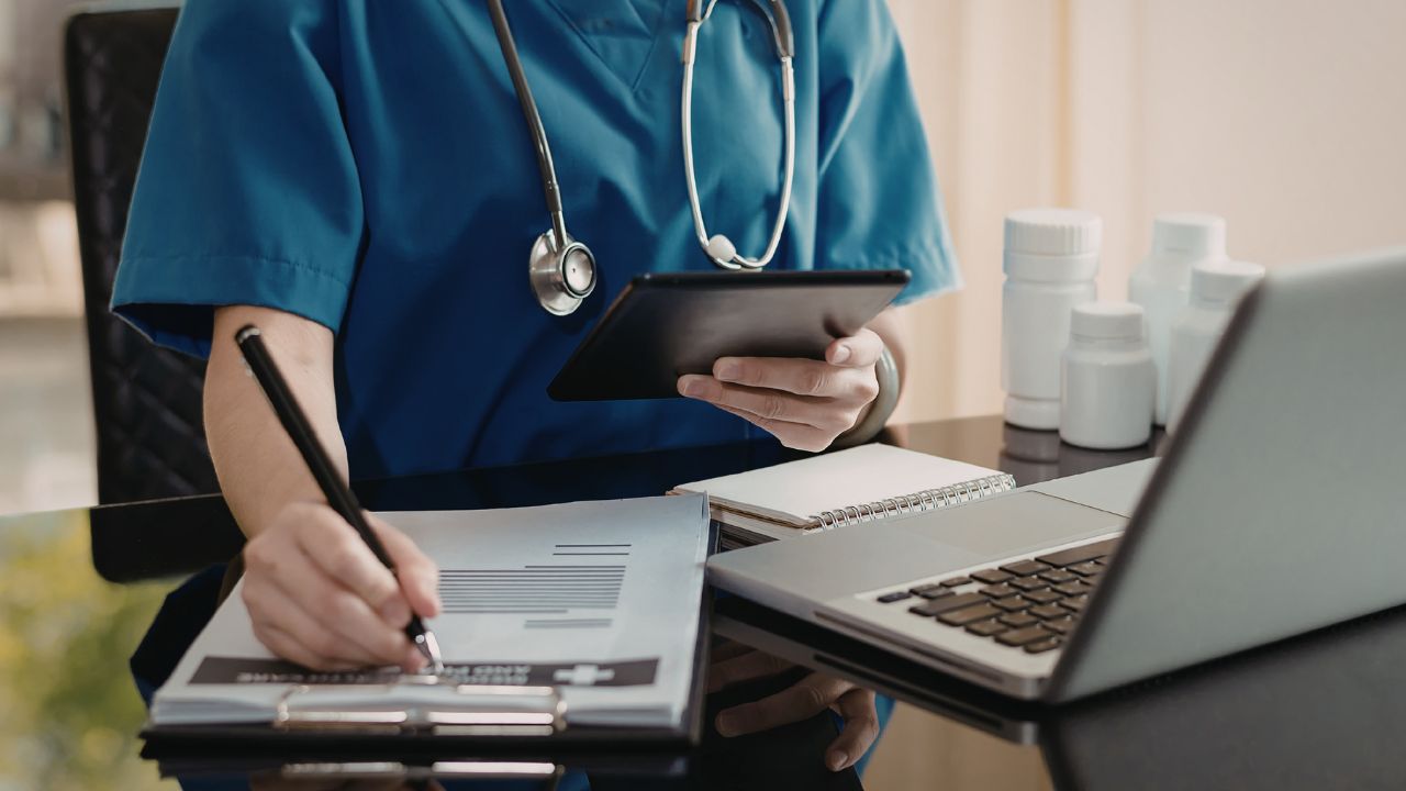 a nurse with a laptop taking notes