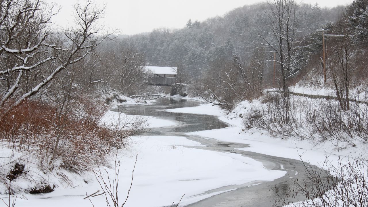 snowy river with mountains in the backdrop