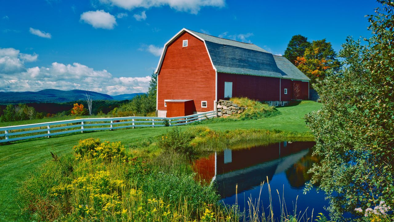 A mountain backdrop with a barn in the fore ground