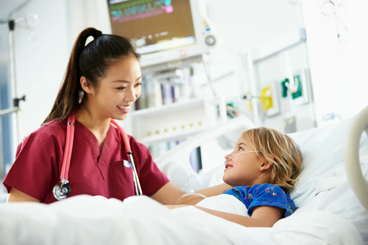 Pediatric nurse at the bed of a patient