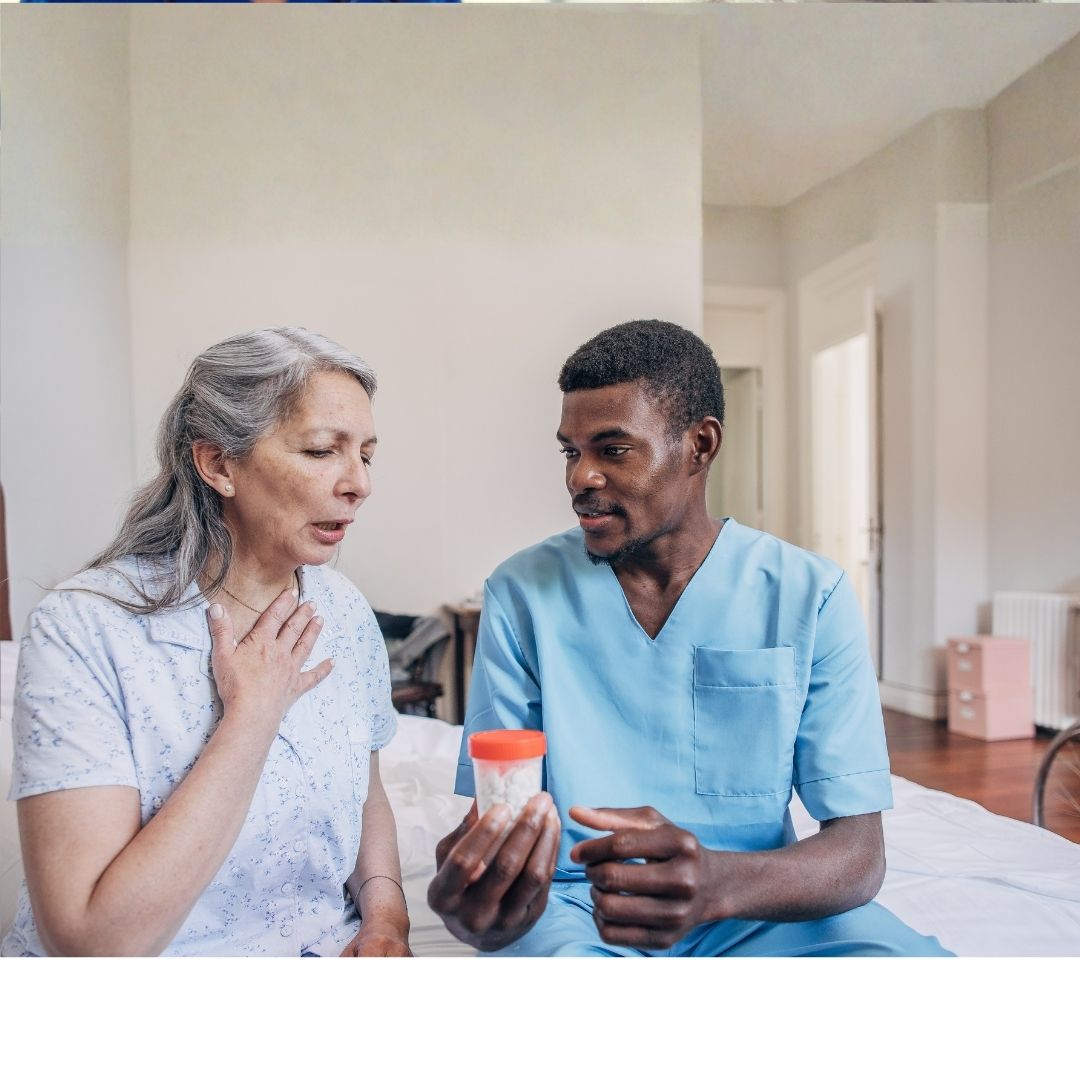 Nurse offering medication to an older patient in a clinical setting