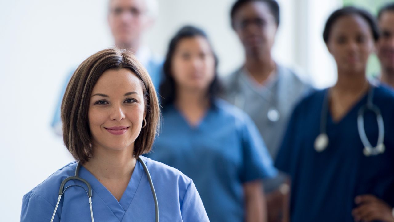 nurse smiling and other nurses in the background