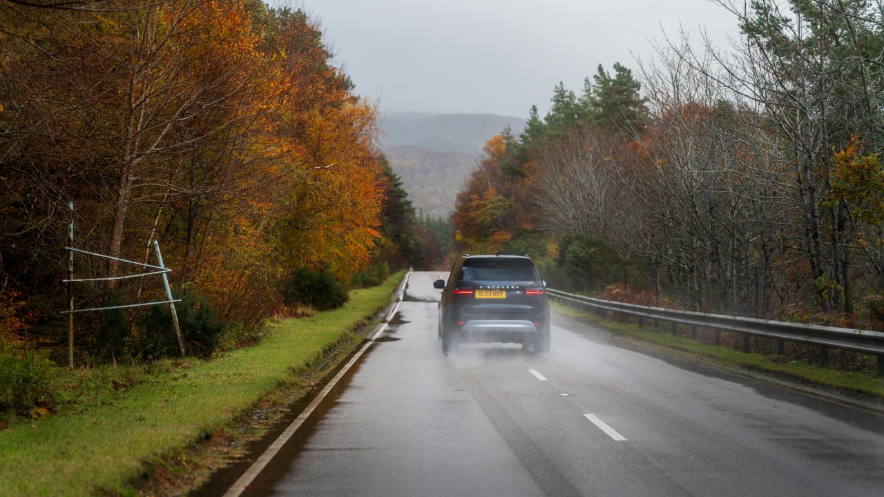 A car going down the road in Fall