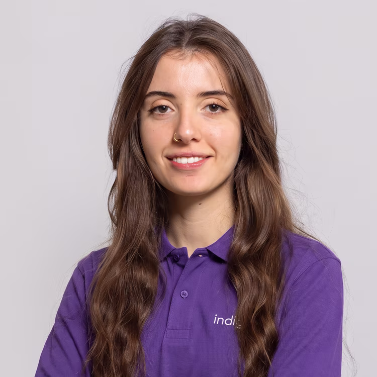 Membro del team di indigo.ai con capelli lunghi mossi e polo viola aziendale