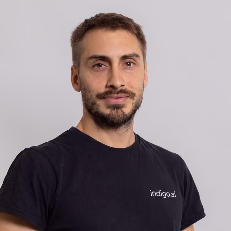 Membro del team di indigo.ai con barba e t-shirt nera indigo.ai