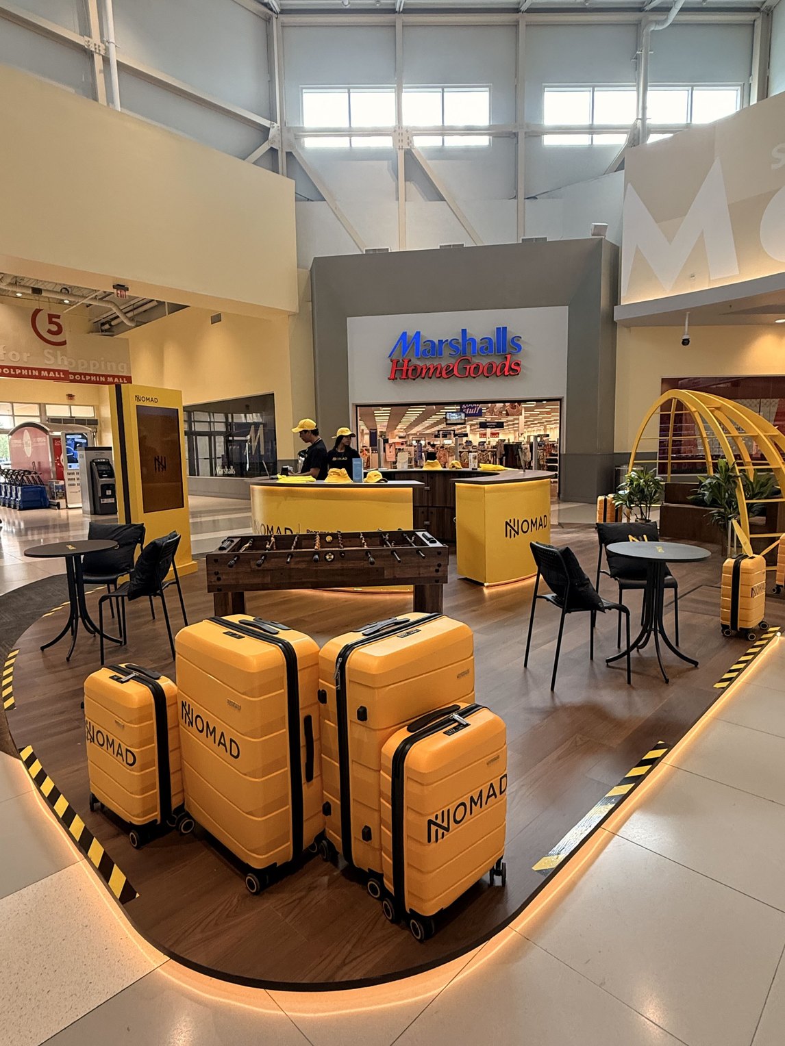 Nomad Point no Dolphin Mall em Miami, com poltronas amarelas e balcão de atendimento