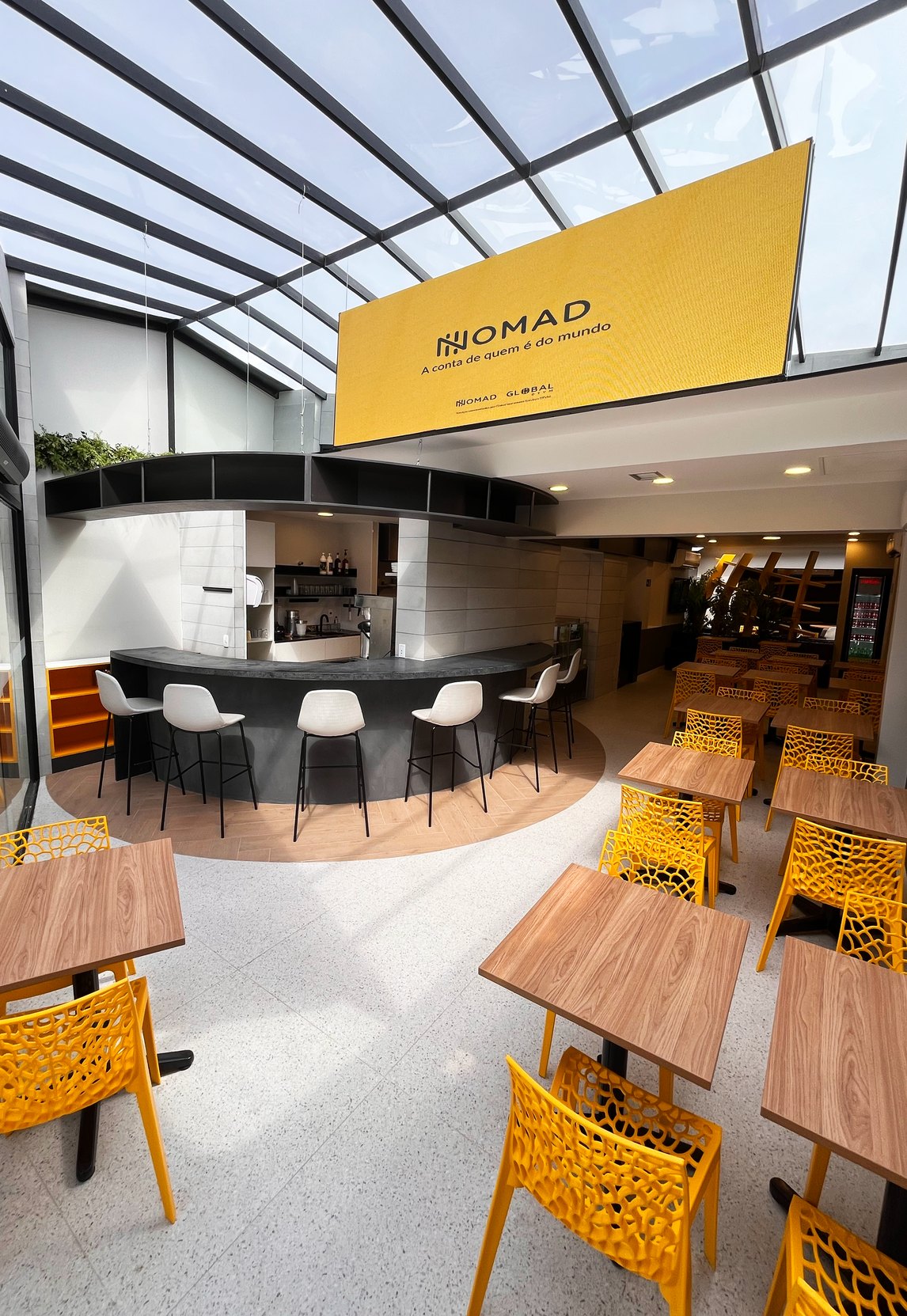 Interior do Nomad Coffee em São Paulo, com balcão central e banquetas
