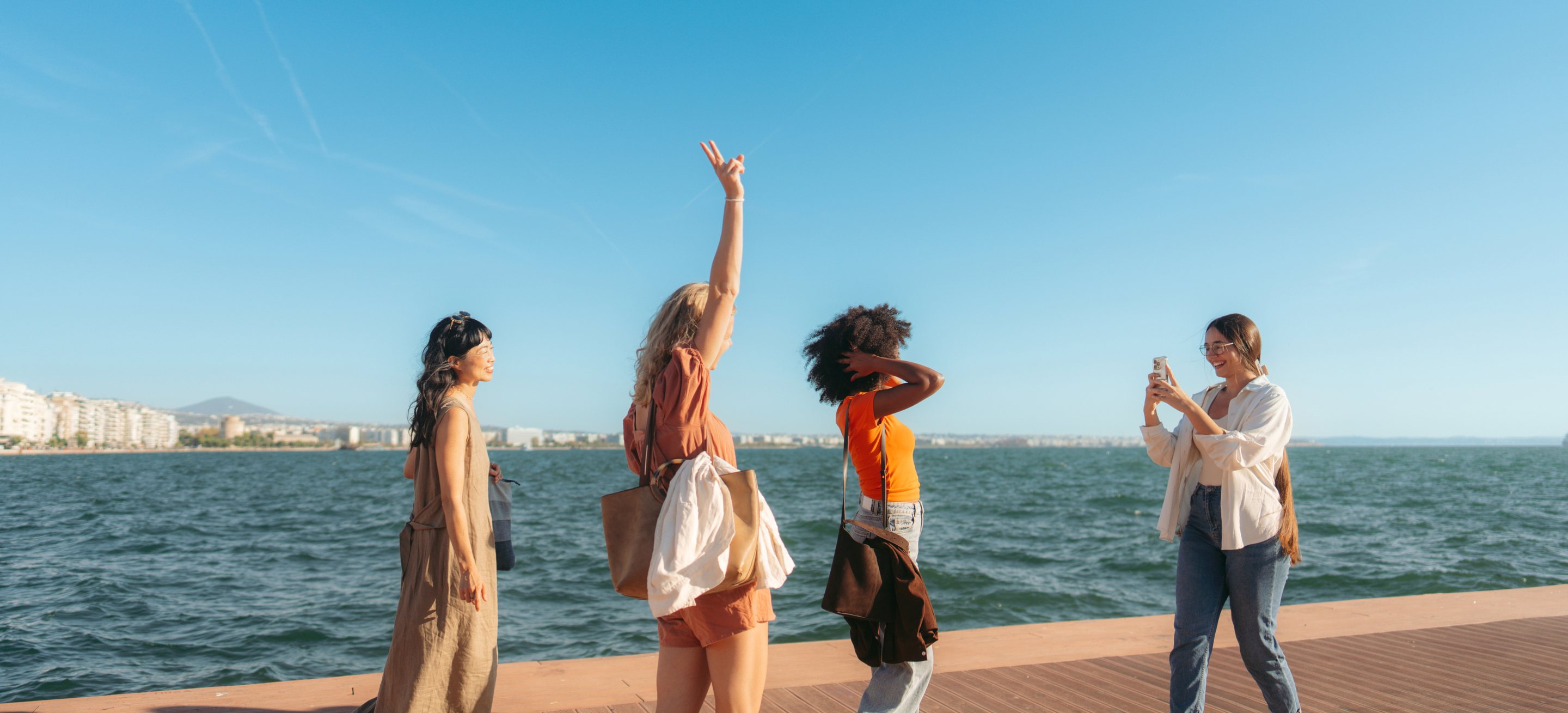 Quatro amigas à beira-mar aproveitando uma viagem