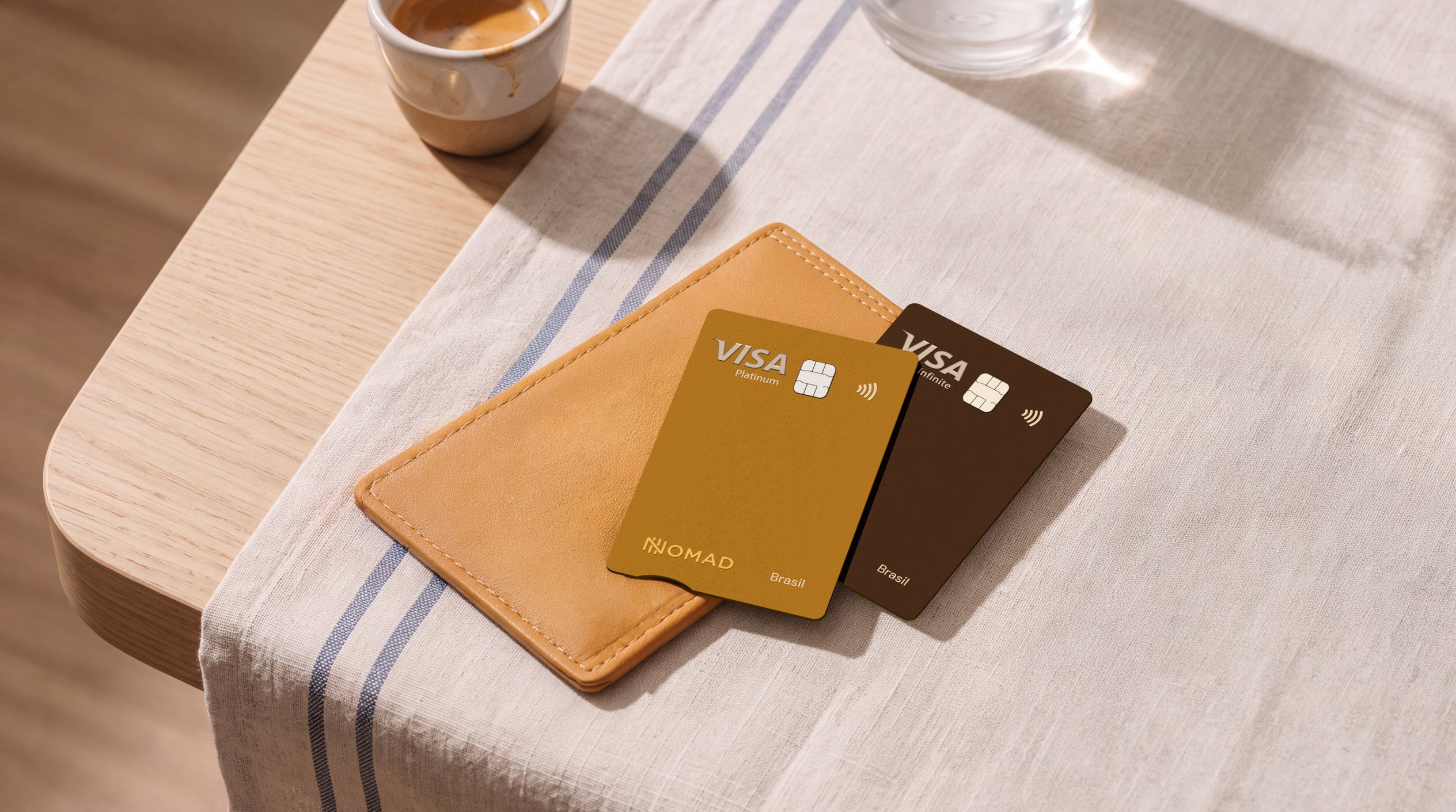 Cartões Nomad Explorer Visa Platinum e Visa Infinite sobre uma carteira de couro