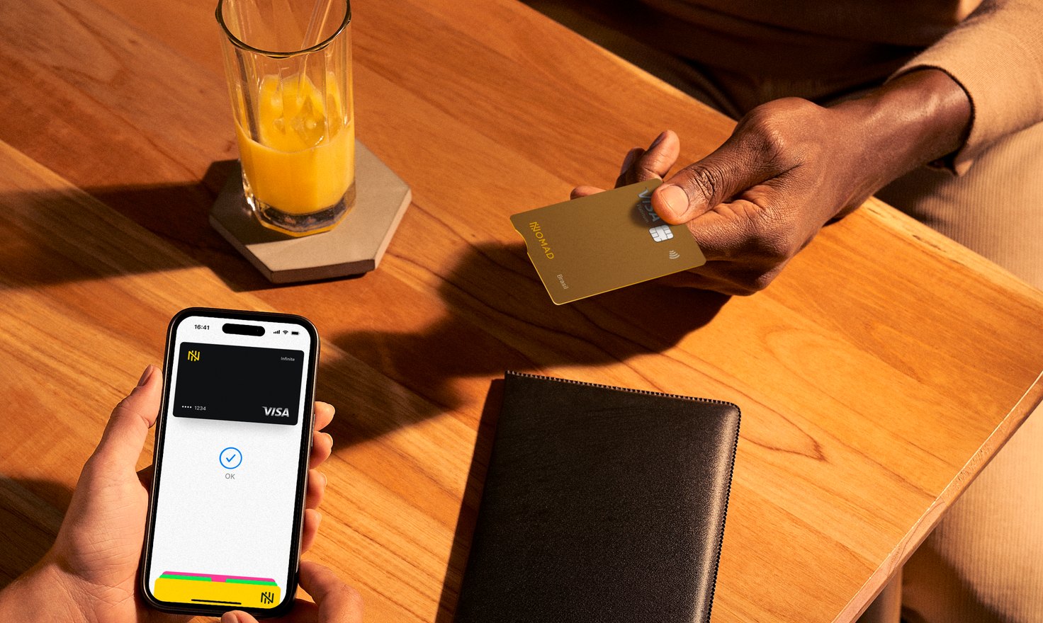 Pagamento com cartão Nomad e celular em uma mesa de restaurante