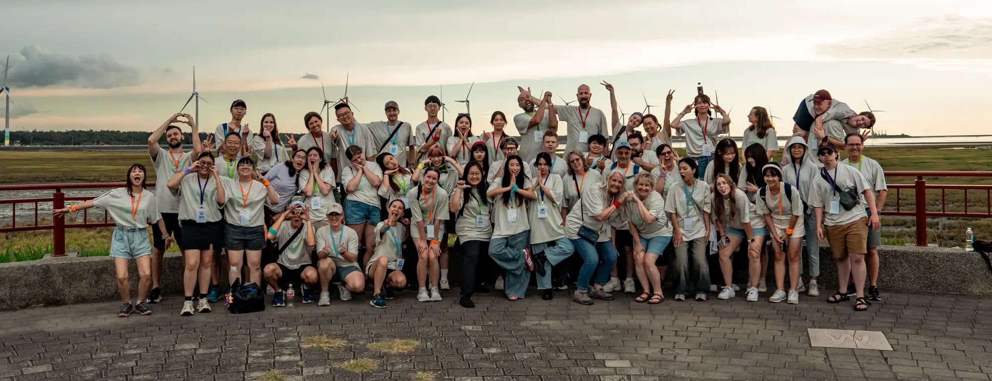 College camp students cheering with their hands raised at Gaomei Wetlands