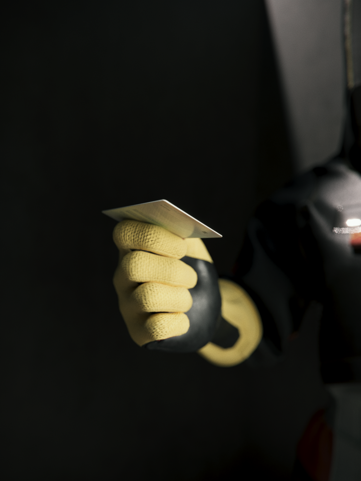 A black, red and yellow futuristic hazmat glove, from Ayla, holding an ID Card from the Settlement of Babylonia in a dark brutalist room in Syntactic Labyrinths.