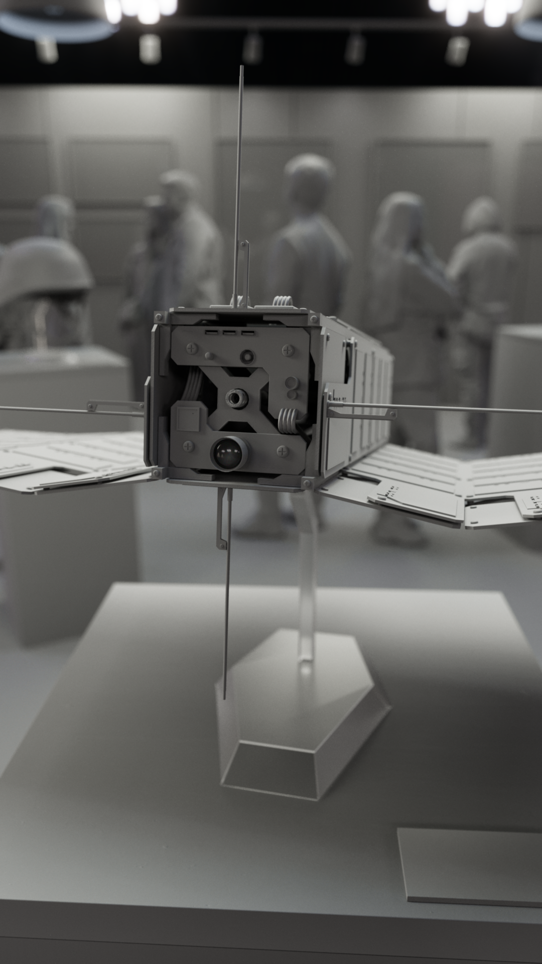A clay render of a military CubeSat displayed on a stand in an art gallery displaying other artifacts and art from Operation: Deli Platter.
