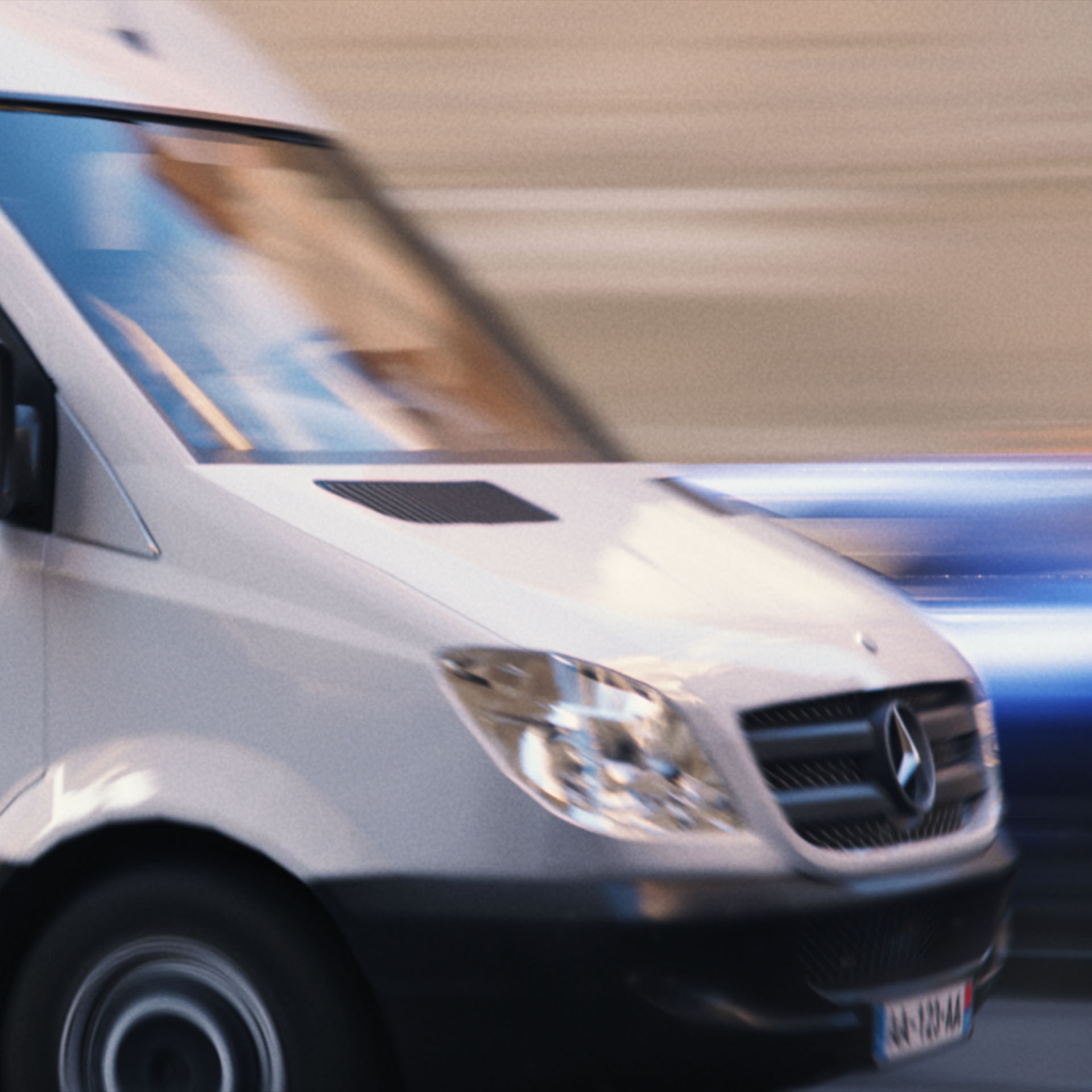 A white Mercedes Sprinter van speeding in motion-blur through the streets of Europa in Heist Club.