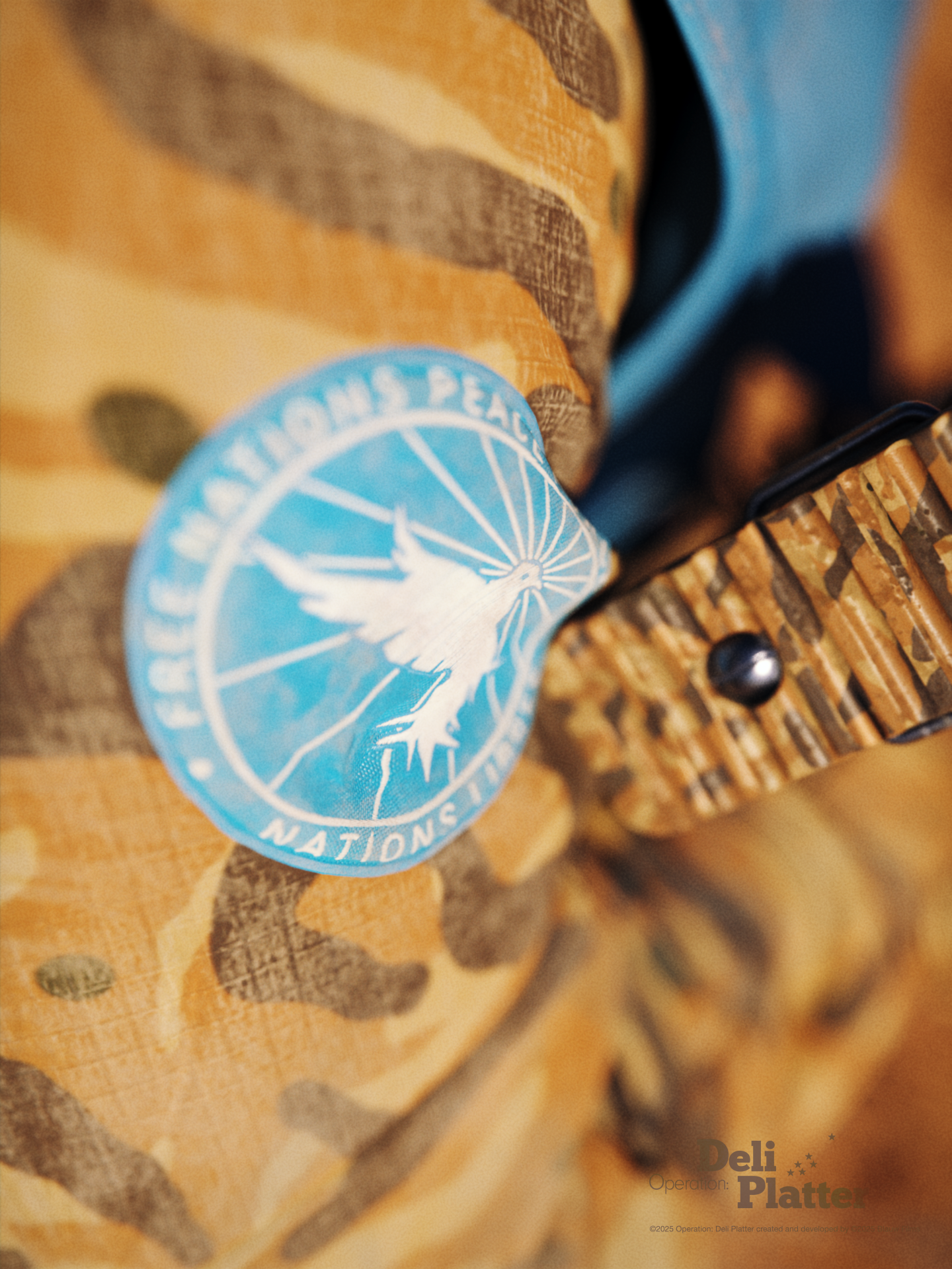 A close-up on a military fatigue with the Sand Root camouflage pattern and a bright blue military patch featuring a white dove with rays coming from it for the Free Nations Peace Force (FNPF) from Operation: Deli Platter.