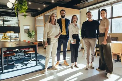 Group of people smiling in a bright, modern office setting