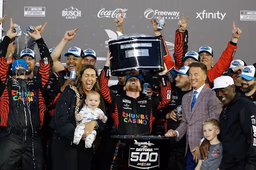 Tyler Reddick and crew holding up trophy after Daytona 500 victory