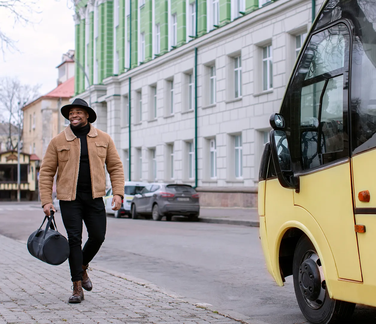 A man walking down the street carrying a bag.
