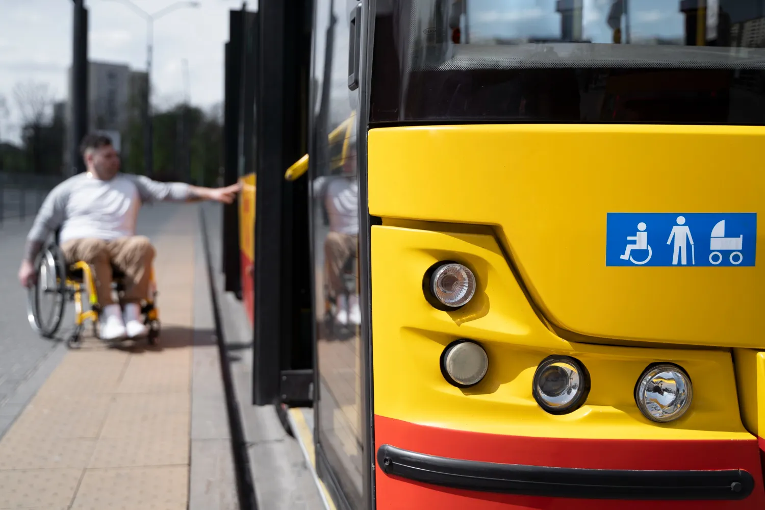 A man in a wheel chair getting on a bus.