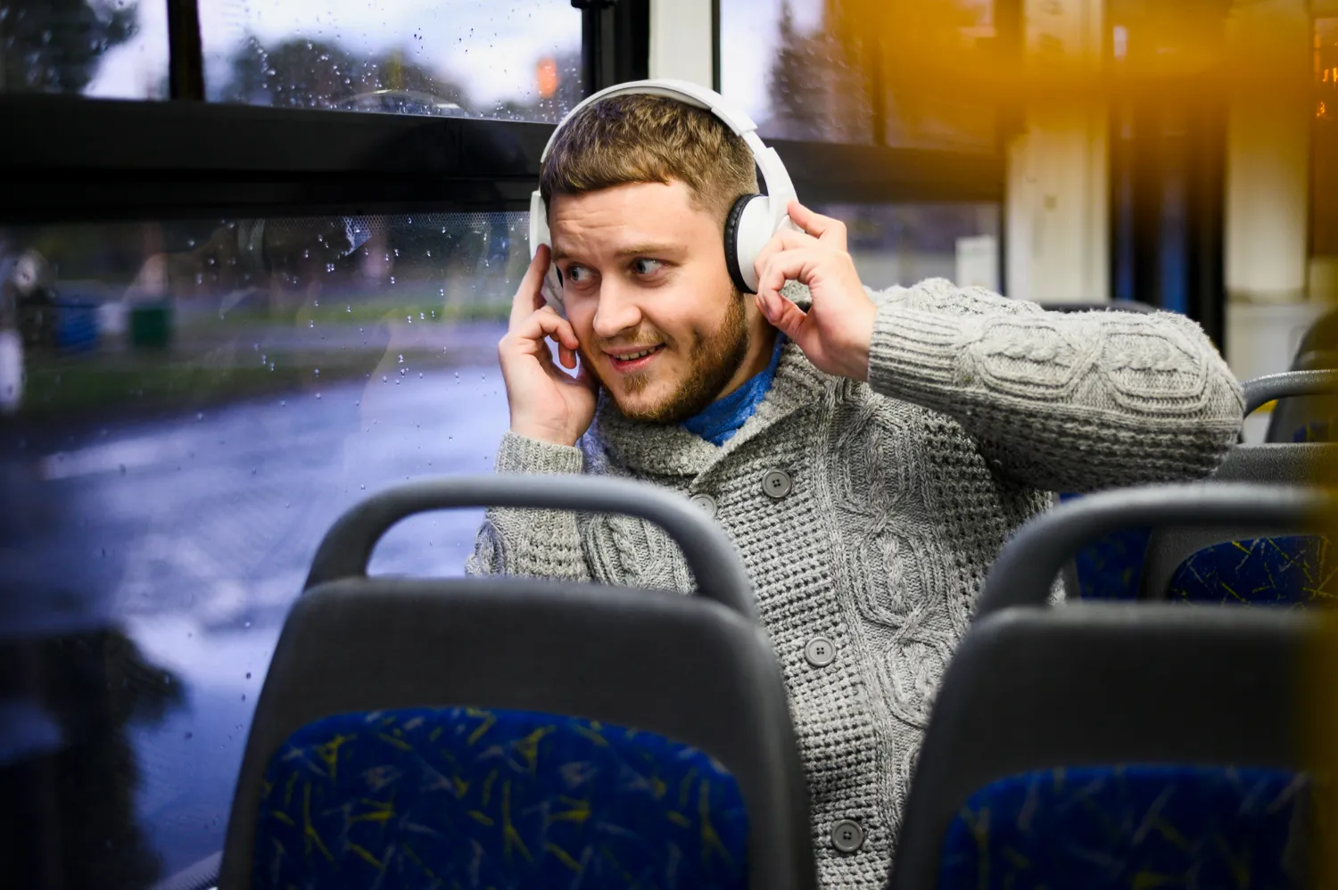 A man sitting on a bus talking on a cell phone.