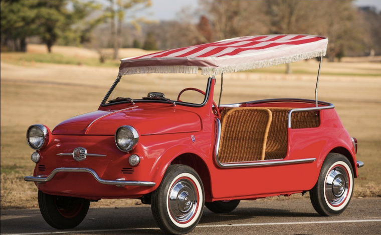 Fiat 500 Jolly avec sièges en osier et capote rayée garée sur la plage