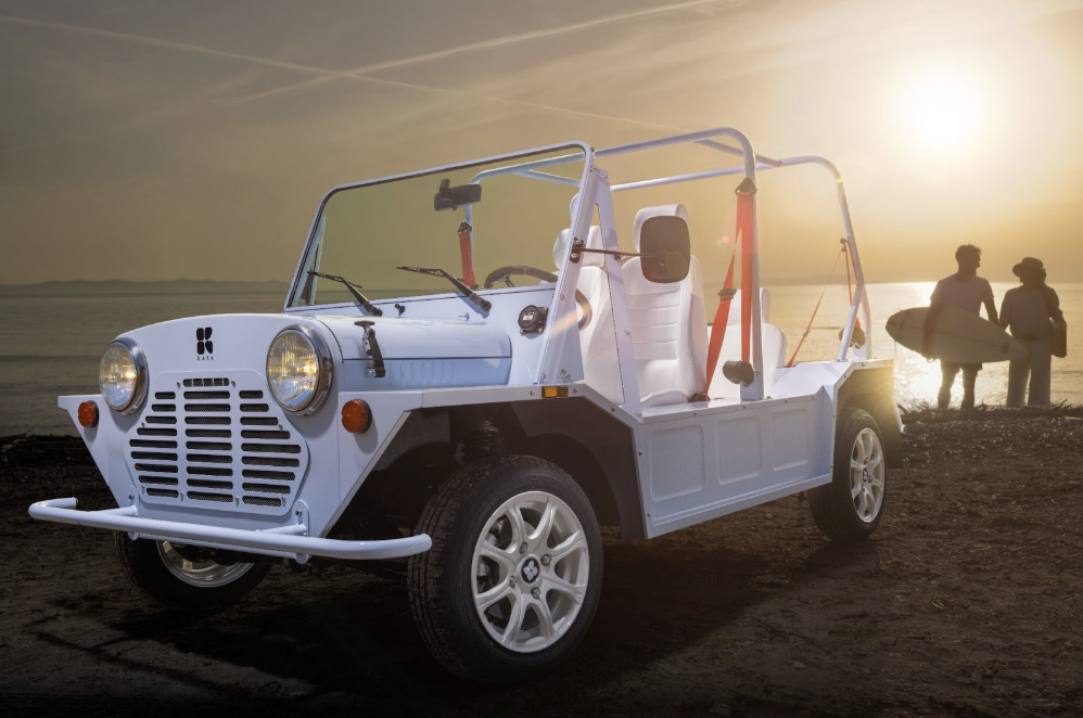 Voiture de plage électrique moderne Kate en bleu clair, garée près des falaises de l'océan