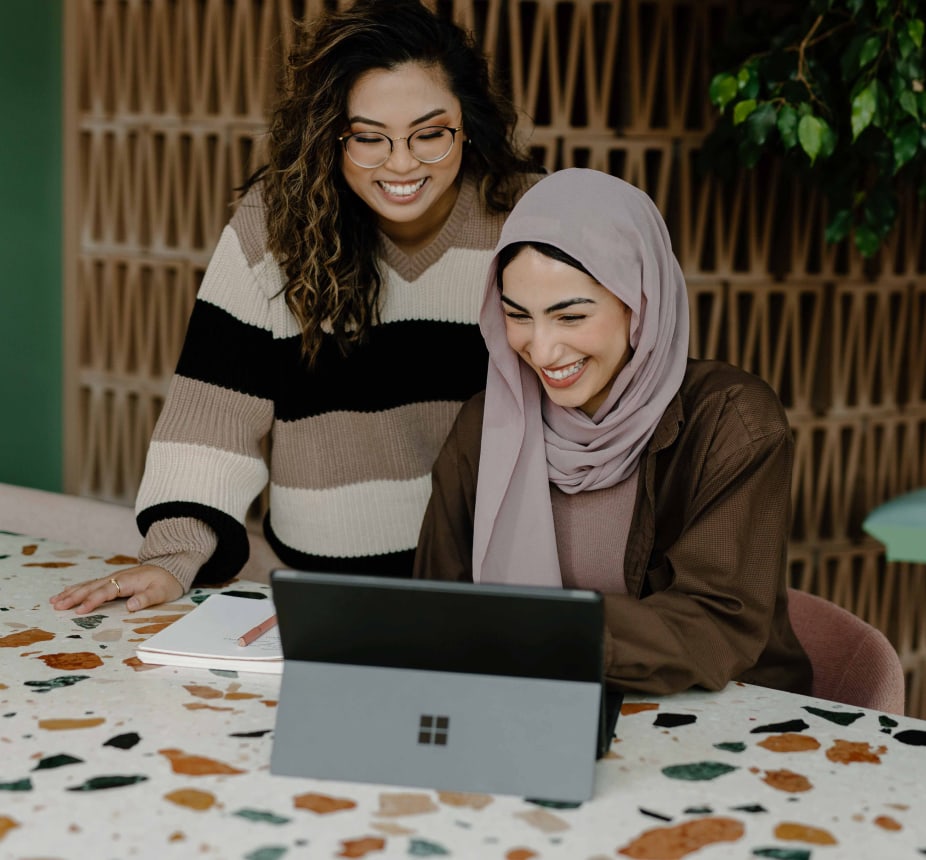 Two women smiling at a computer