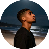 Testimonial picture showing a side-
profile of someone standing at the beach at night time