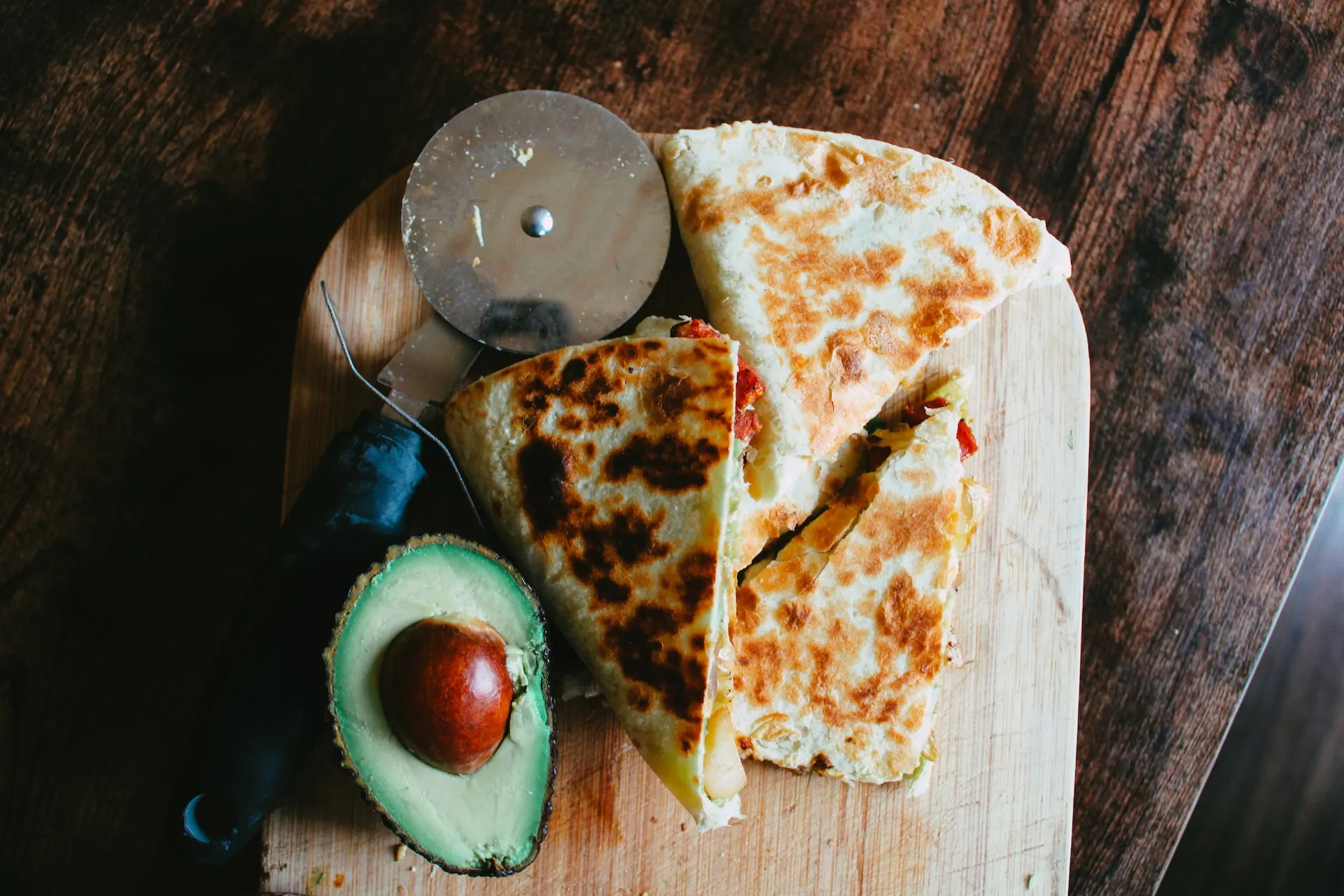 Overhead image of quesadilla with avocado and cutter