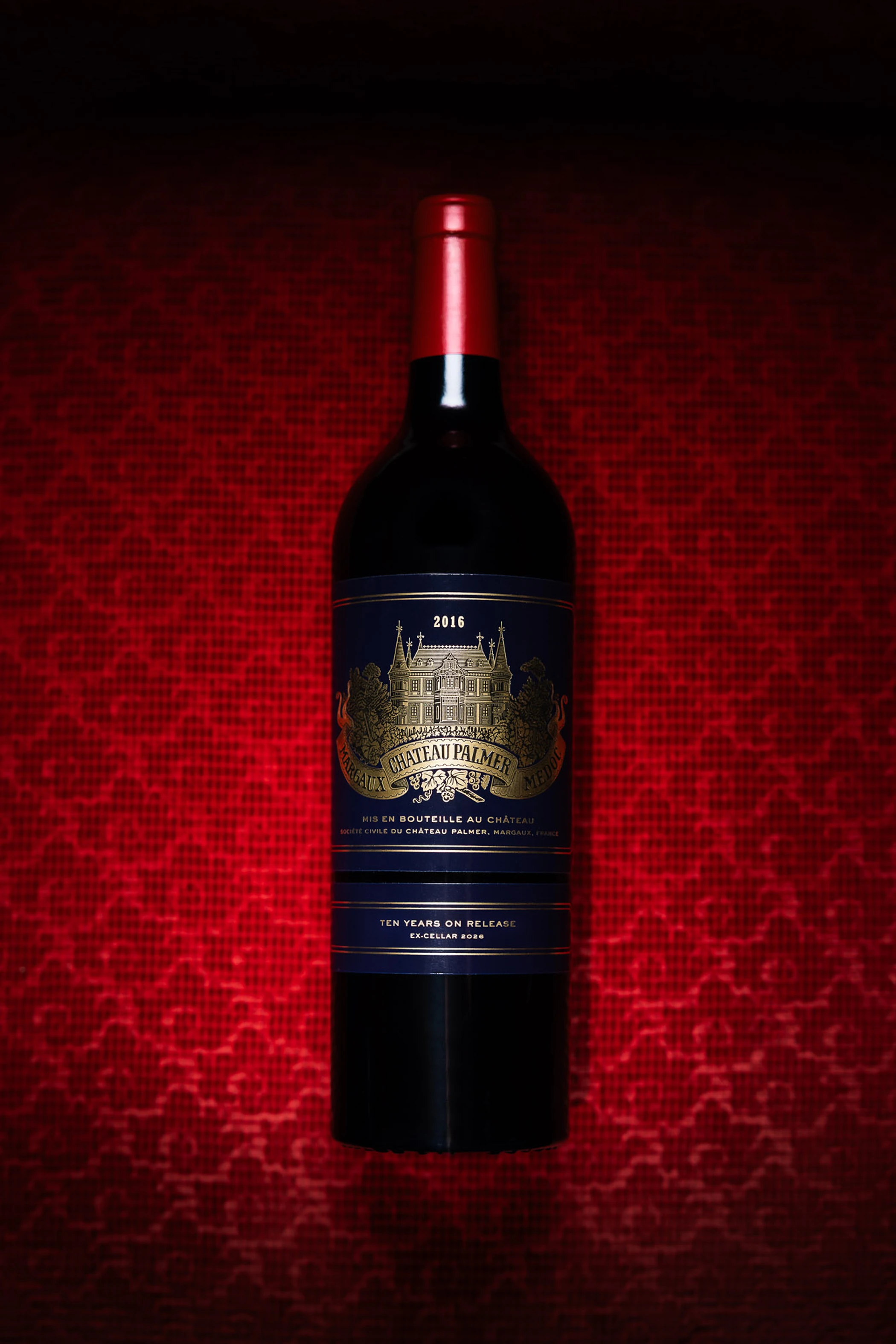 Bouteille de Château Palmer 2016 sur un fond de velours rouge