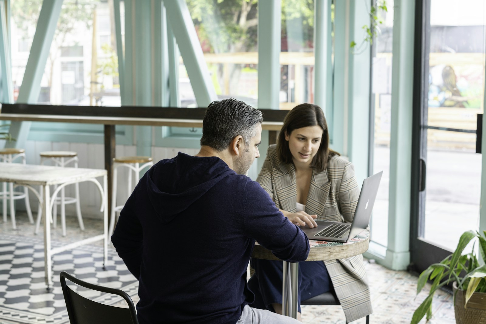 Deux personnes en réunion devant un ordinateur portable pour discuter d une stratégie de présence locale et d outils IA (photo LinkedIn Sales Solutions via Unsplash)