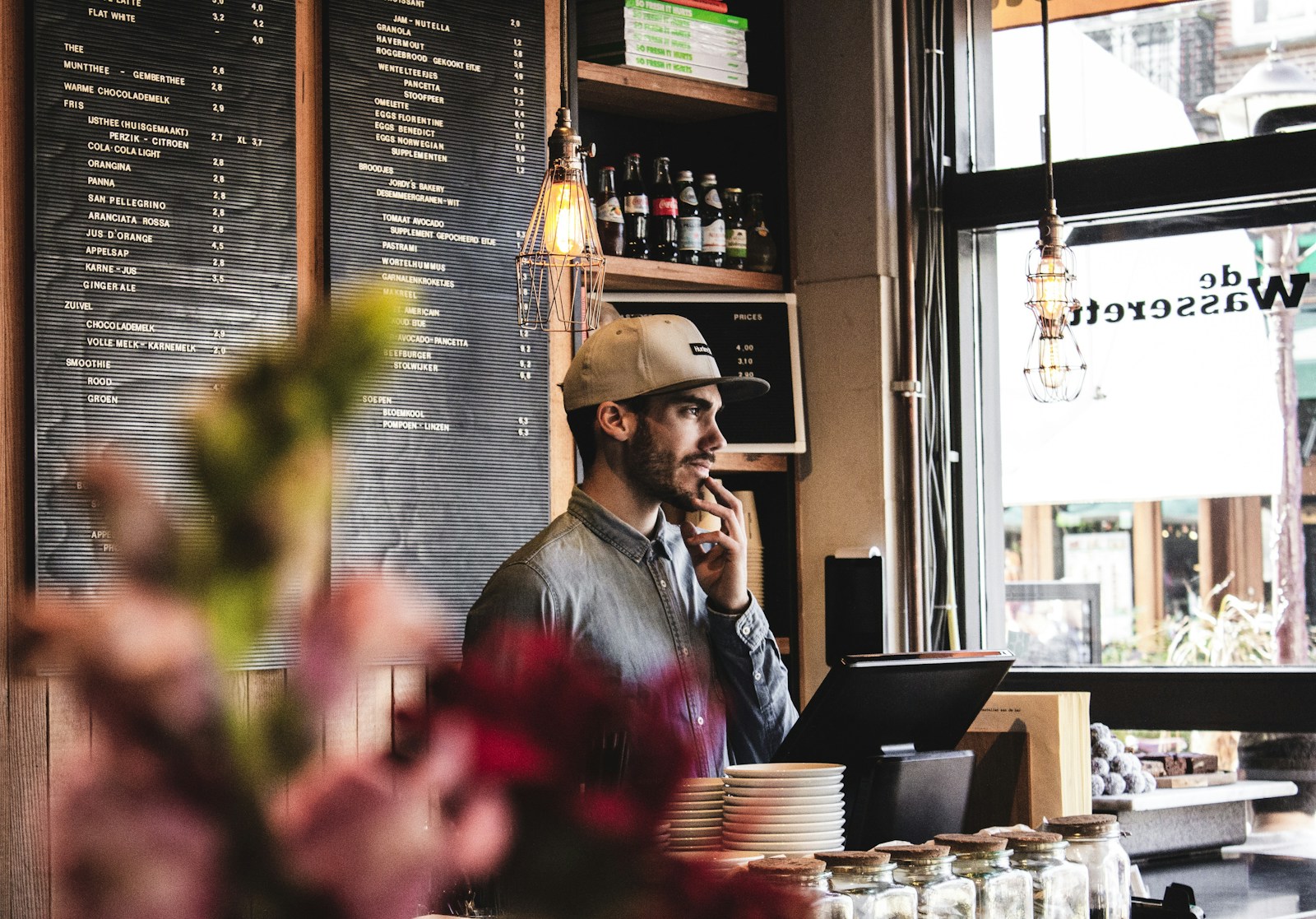 Client à table utilisant un smartphone pour interagir avec un agent IA (photo Louis Hansel via Unsplash)
