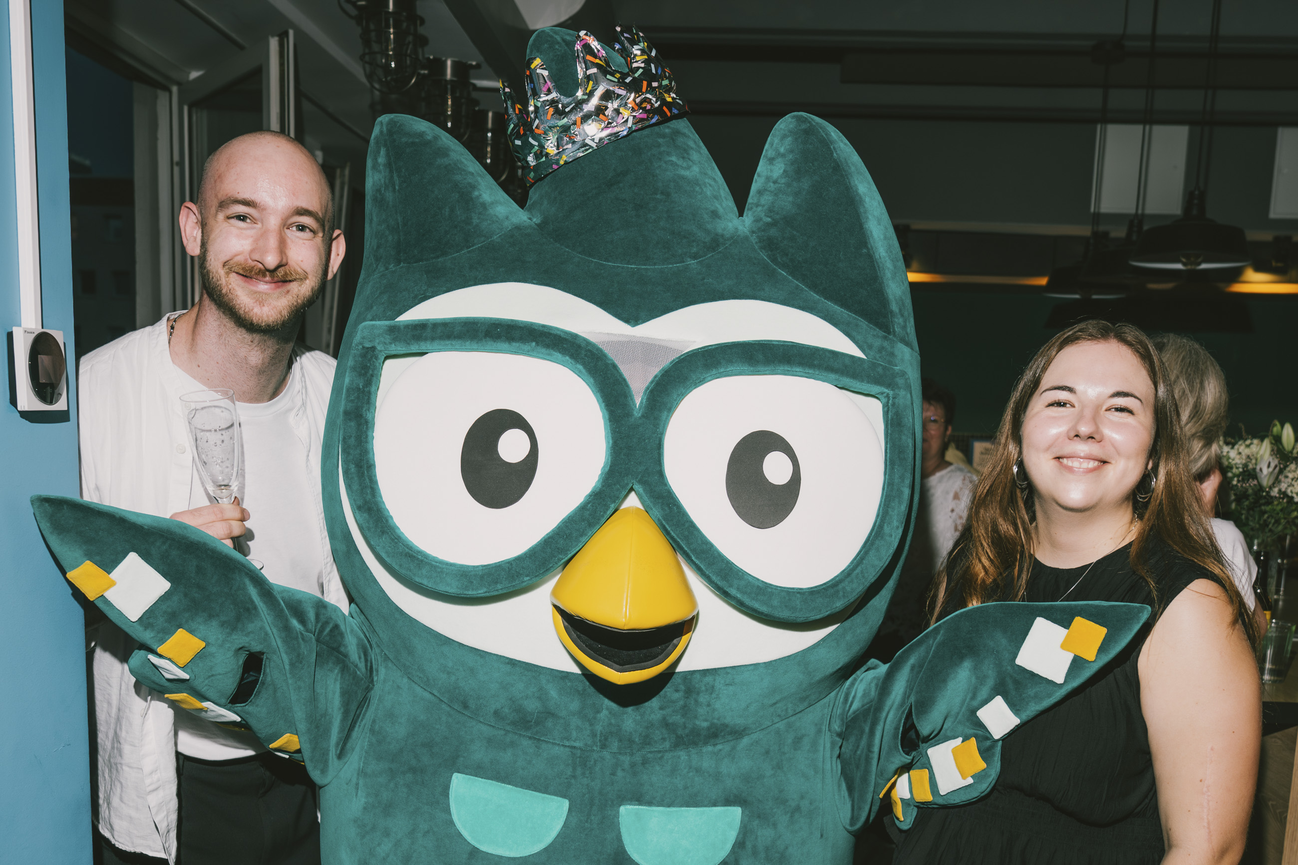 Maskottchen Loki mit zwei Gästen auf der Feier