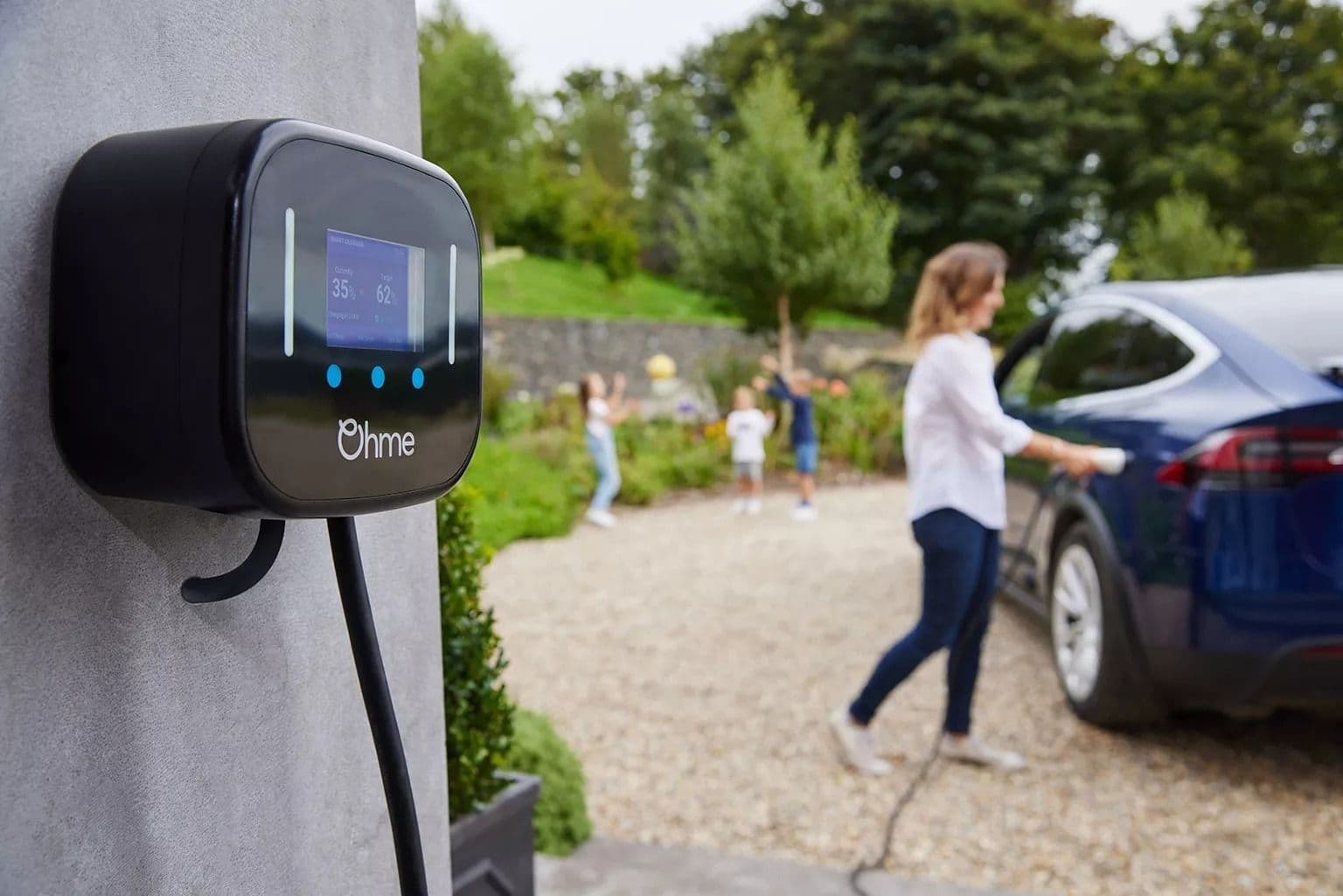 Ohme Home Pro home EV charger mounted on a house wall