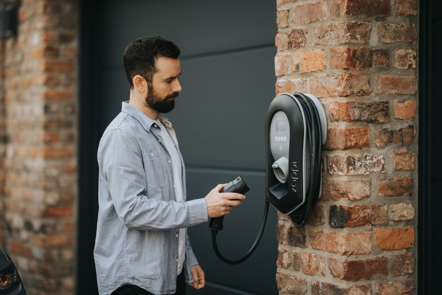 myenergi Zappi EV charger on a brick house wall