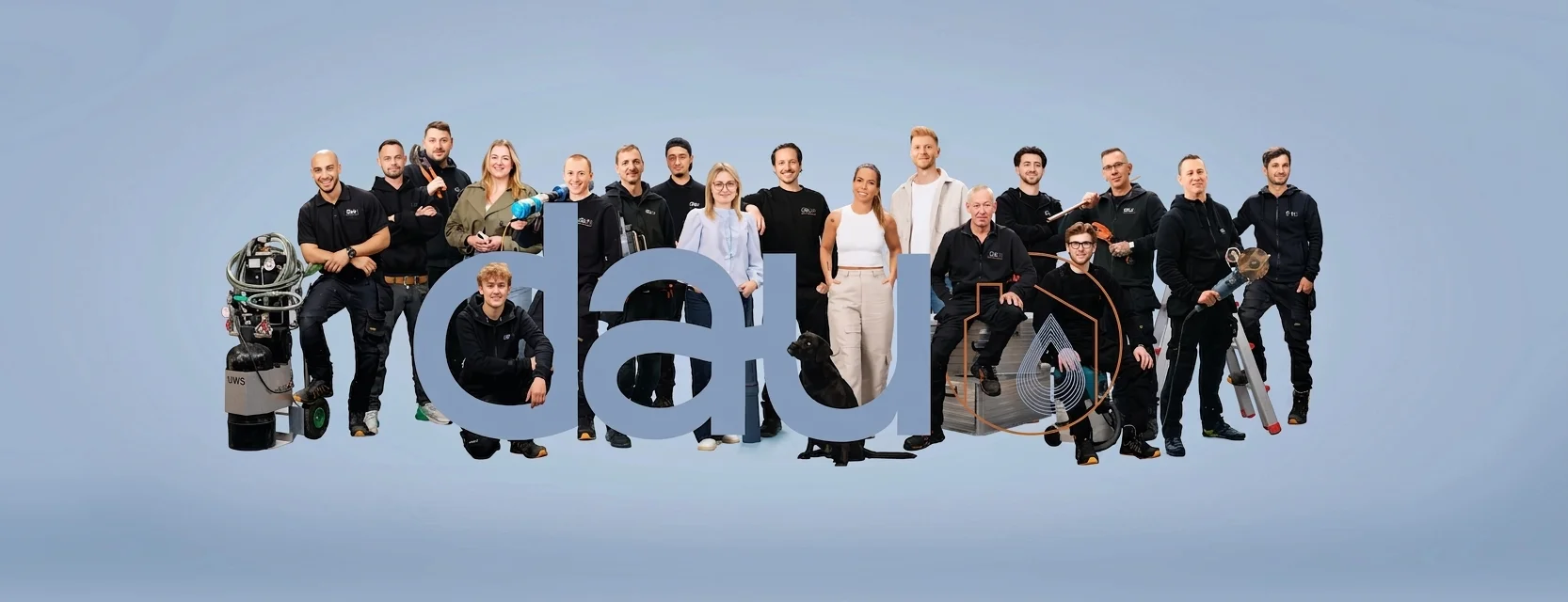 Gruppenfoto von 18 Personen vor hellblauem Hintergrund mit Buchstaben „dau“ in der Mitte.
