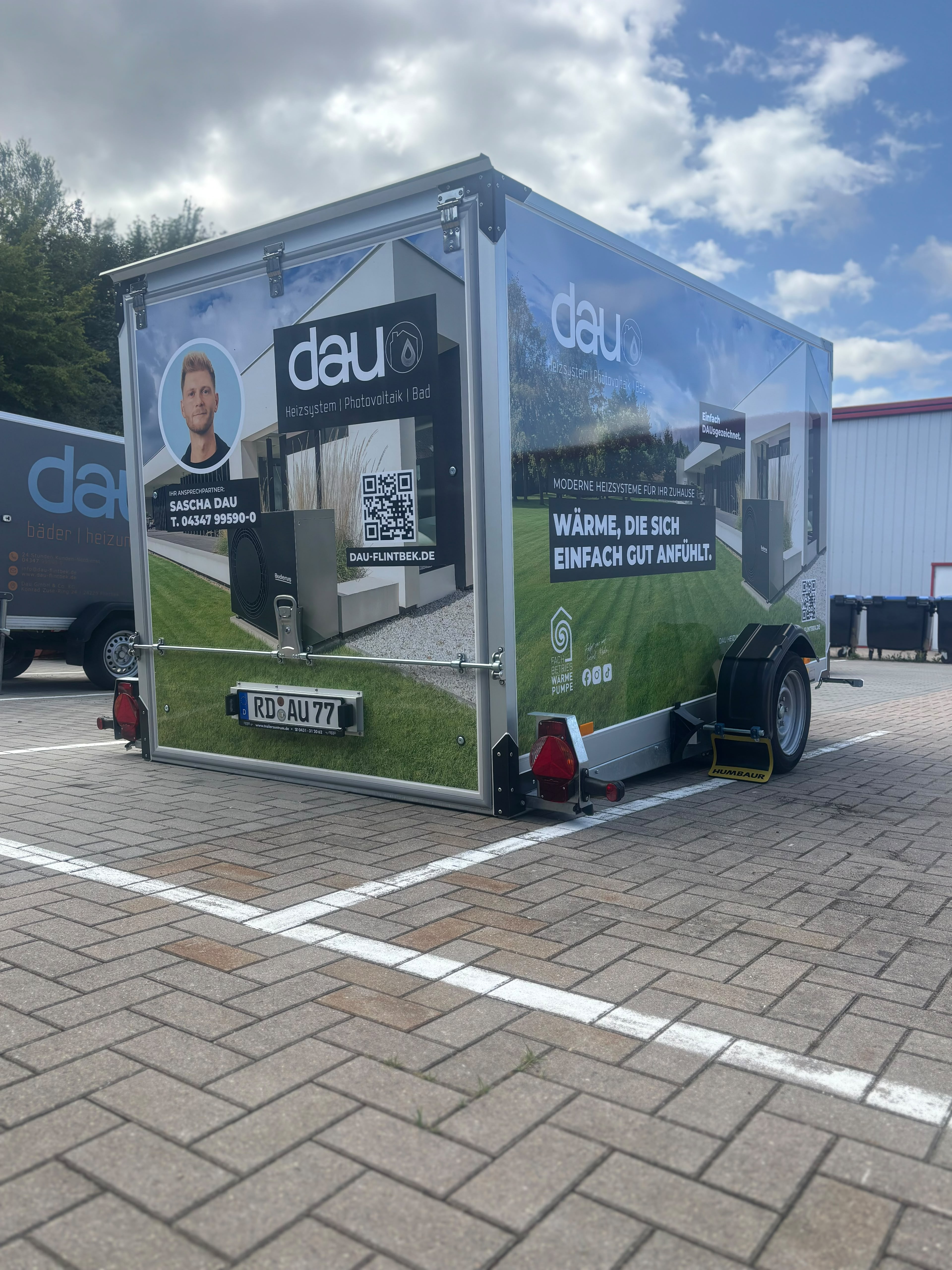 Mann installiert oder wartet eine Wärmepumpe neben einem Backsteinhaus im Garten.
