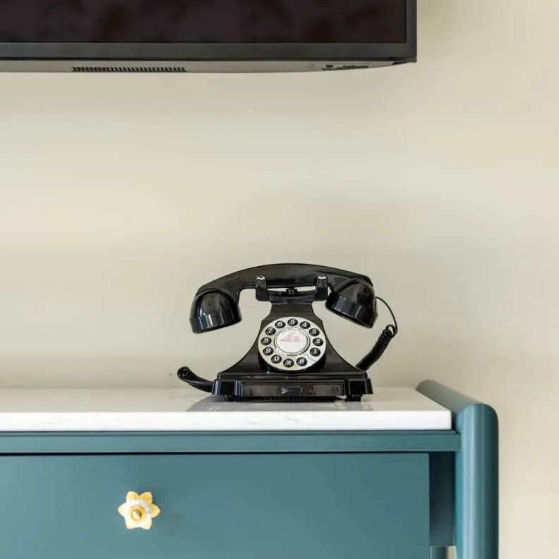 Old school telephone sitting on a blue furniture