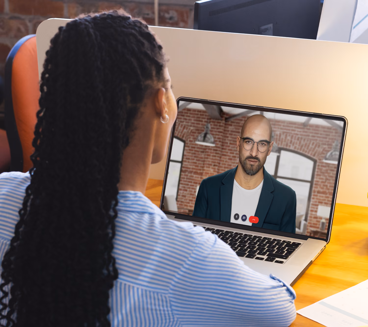 A female sales rep sitting at her laptop and roleplaying with a male UneeQ digital human using UneeQ's Immersive Training Platform.