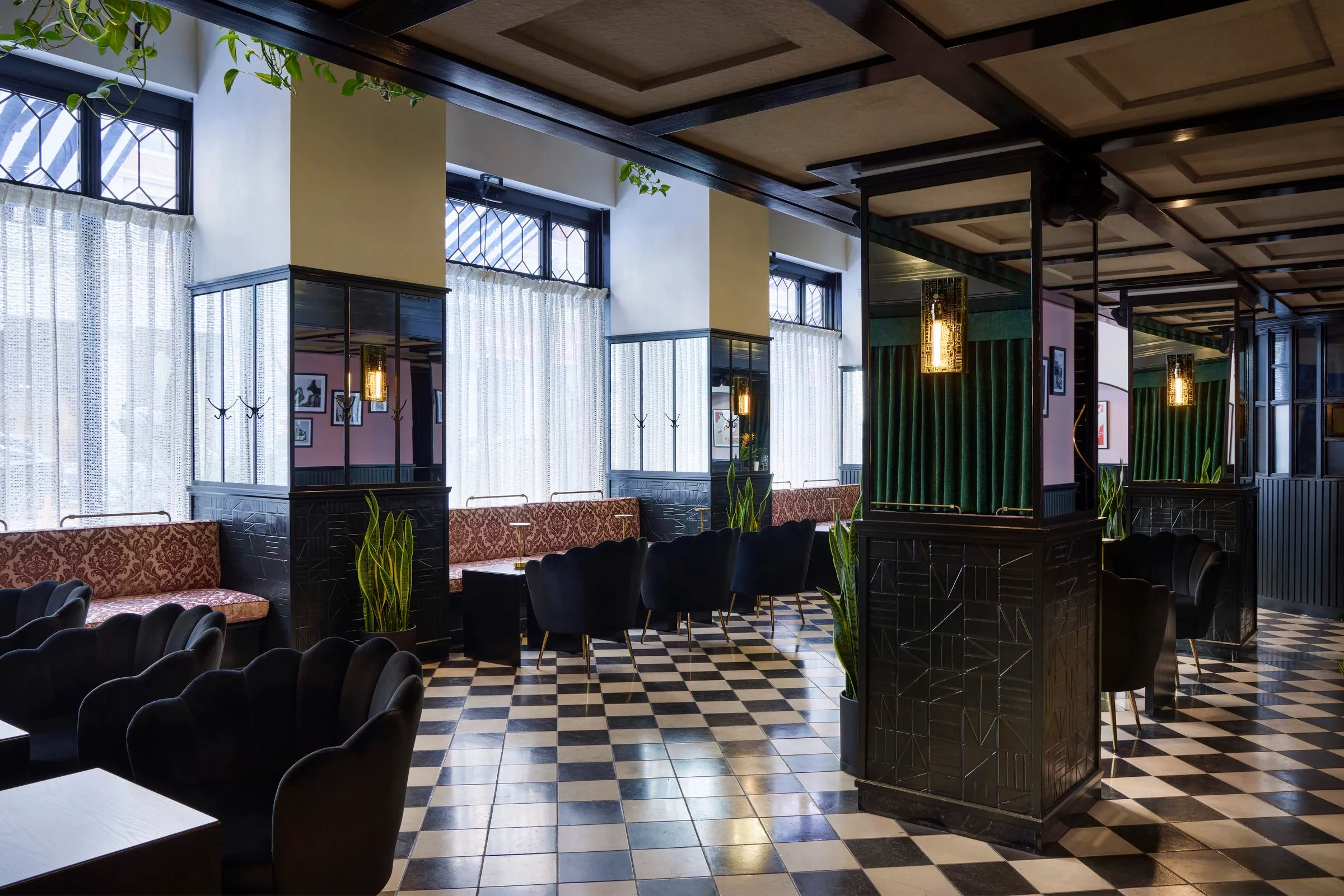 Mirrored columns, pink damask banquettes and black scalloped chairs on checkered tile at Mary at the Stile Hotel.