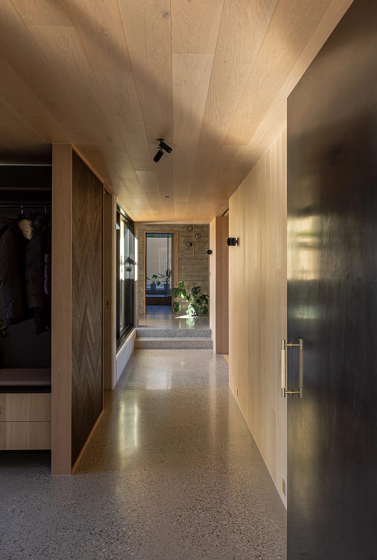 Black oak herringbone floorboards repurposed as wall cladding