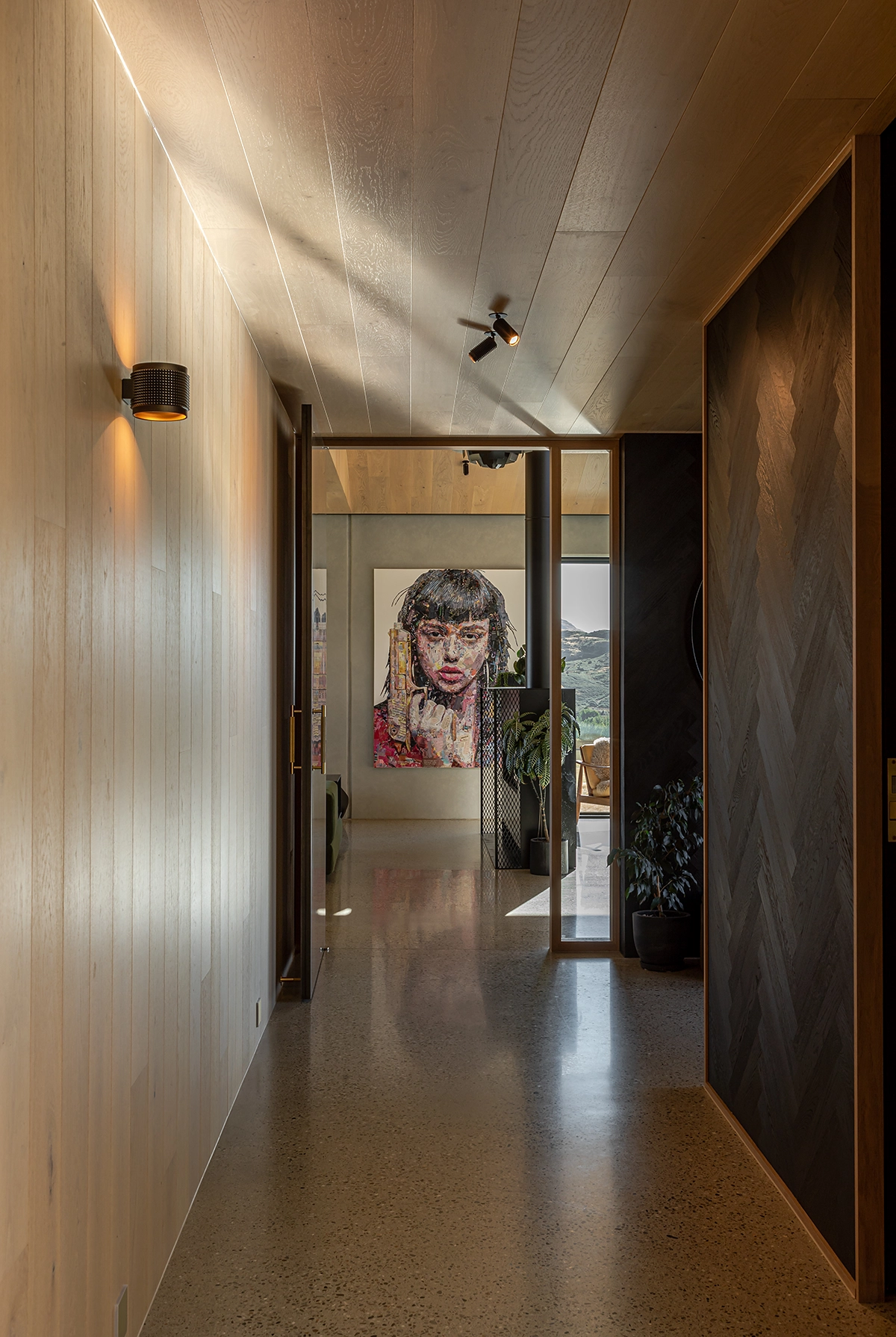 Warm blonde timber planks on ceiling with black herringbone wall