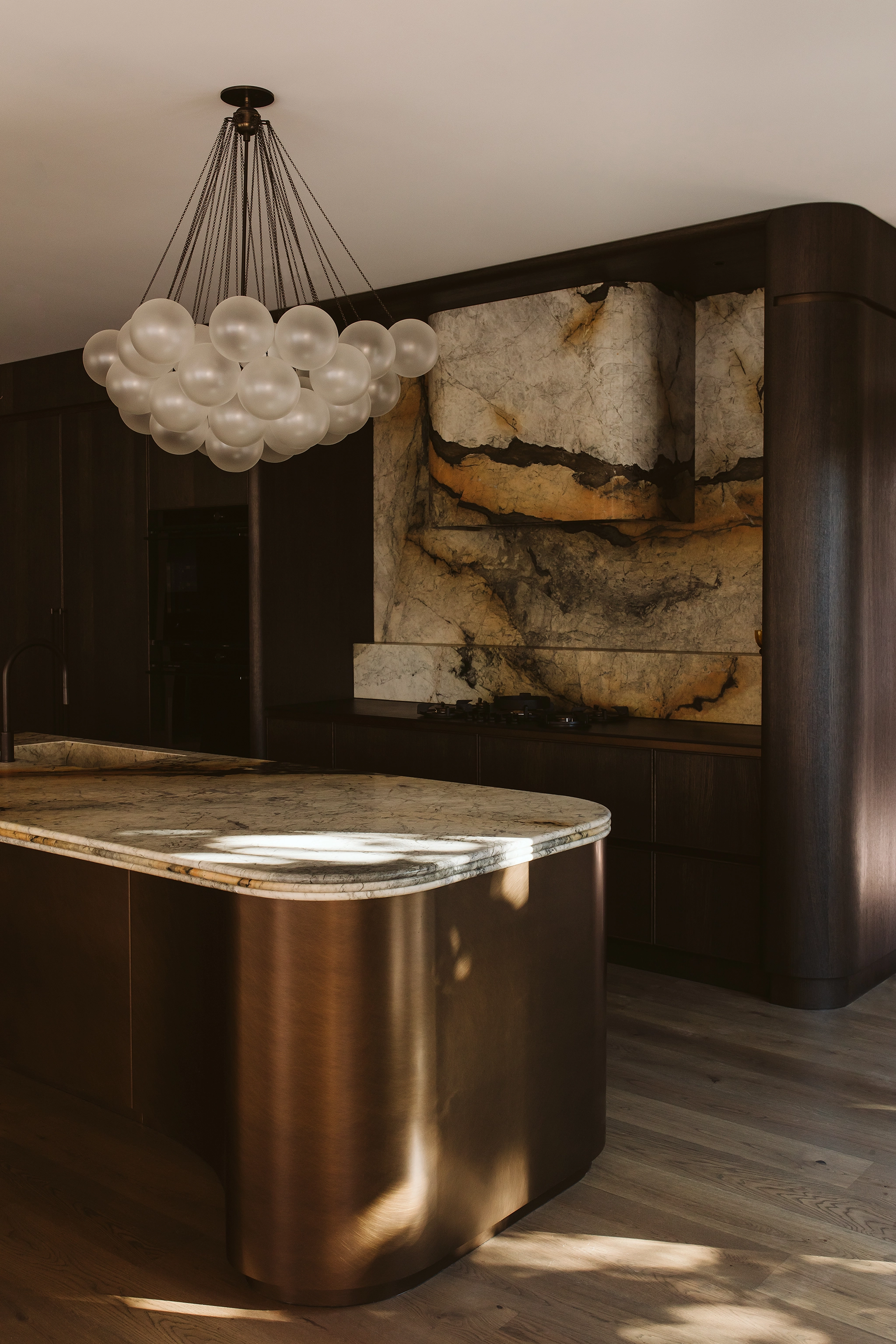 Curved kitchen island with marble and timber details