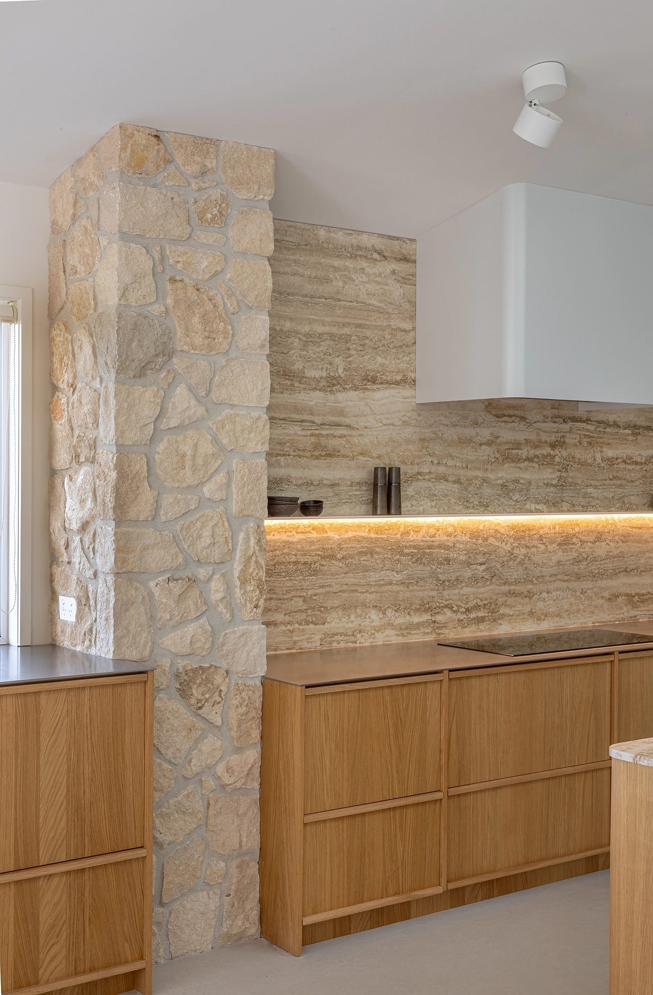 Framed cabinetry kitchen with integrated handles and stone features
