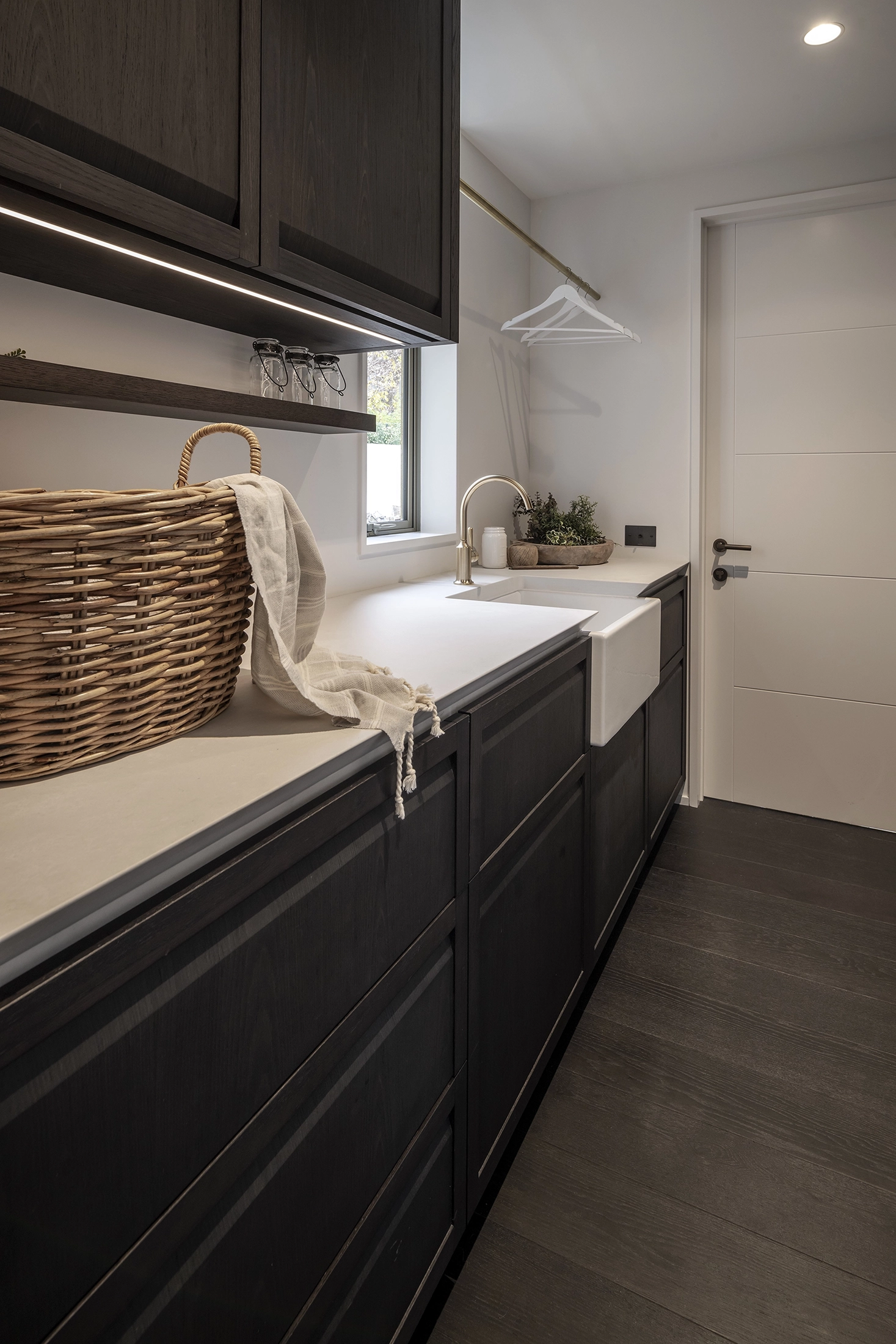 Laundry room with dramatic lighting and dark timber flooring