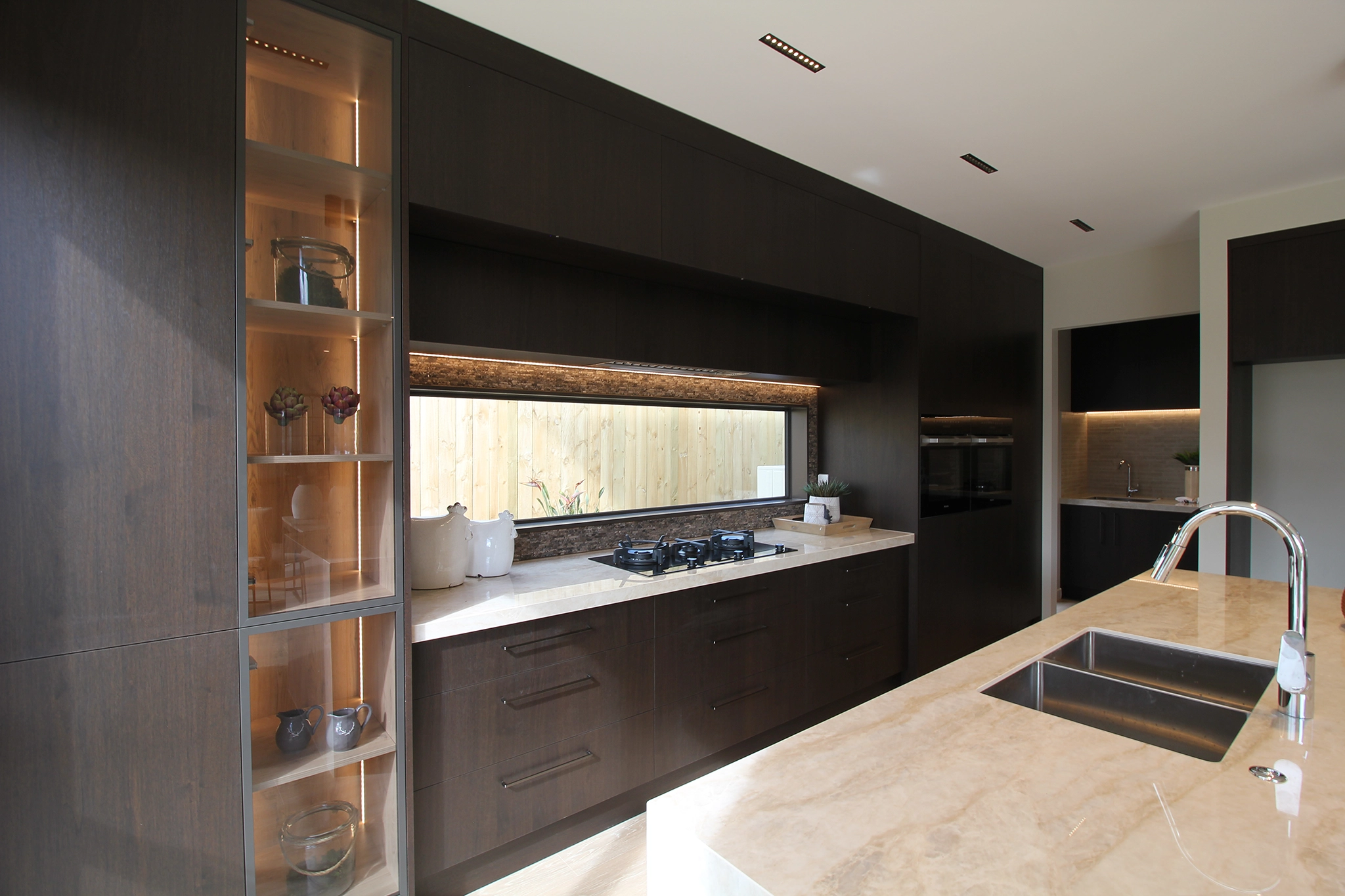 Stardust Walnut dark timber joinery full-height cabinetry with stone bench top, Pepeke Way, Auckland