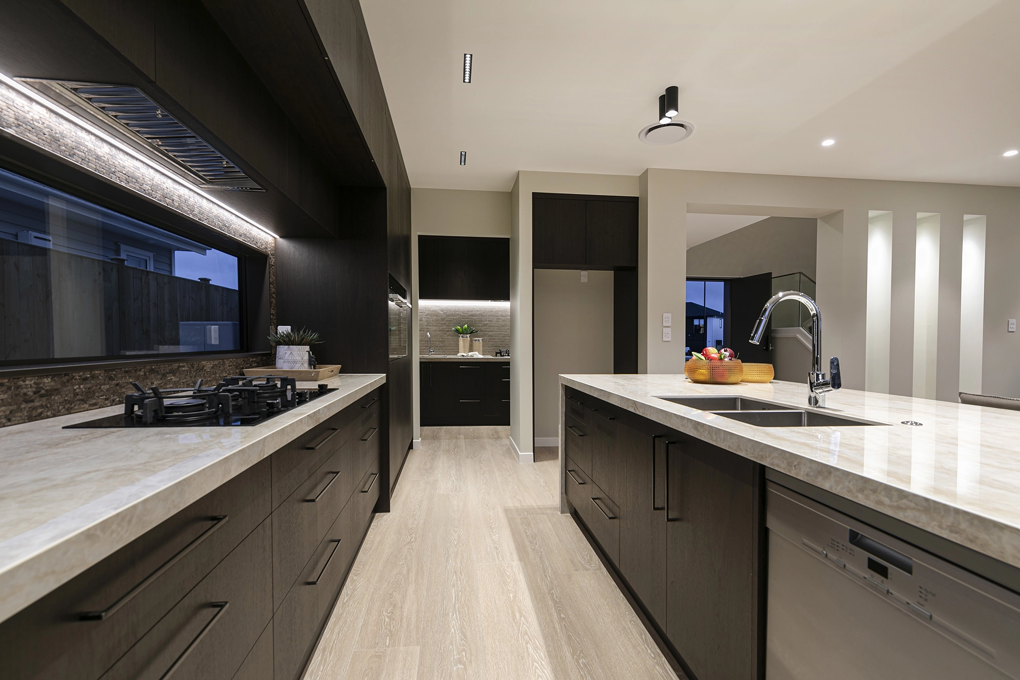 Dark timber joinery with Deep grain Shinnoki veneer in an open-plan kitchen