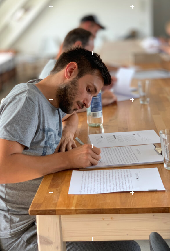 Foto einer Person die gerade im Seminar ihr Zukunftsbild auf Papier schreibt