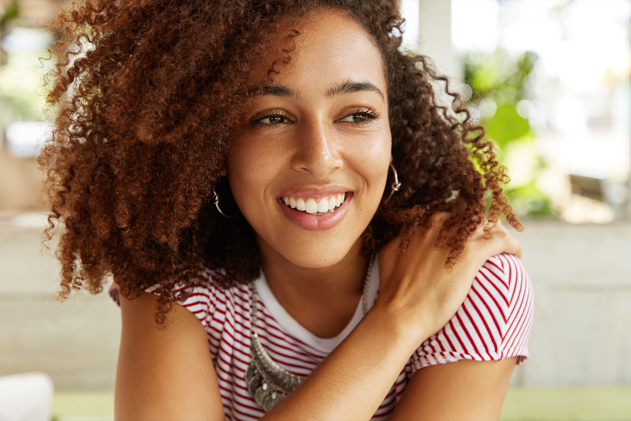 Black-and-white portrait of a smiling woman in a bright setting