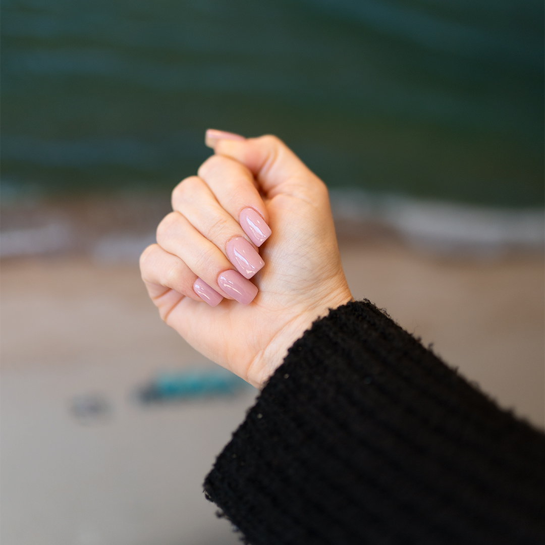 Social media content showing a manicure with glossy light pink nail polish for a Long Island nail salon.